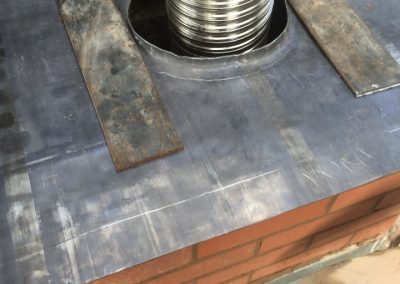 Installing a code 5 lead damp-proof tray for chimney on roof and laying steel supports to carry concrete flue liners
